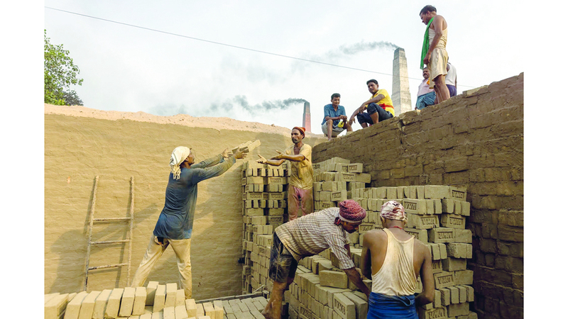 عمال يجمعون الطوب استعداداً لحرقه في الفرن. من المصدر