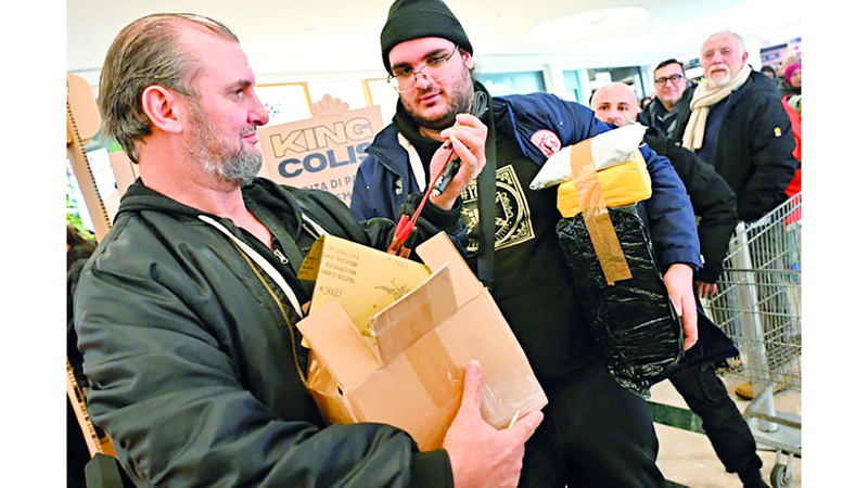 أحد الزبائن يفتح طرده الغامض وسط مراقبة العيون. أ.ف.ب