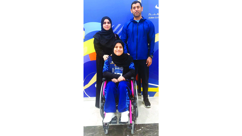 البطلة الإماراتية مع والديها. من المصدر