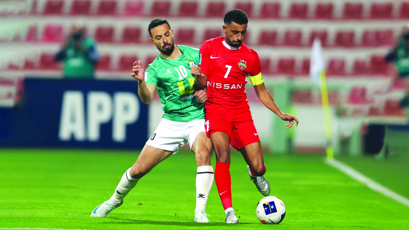 لاعب الوحدات صالح راتب في صراع مع لاعب شباب الأهلي حسن سهيل. تصوير: سالم خميس