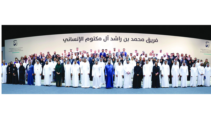 محمد بن راشد في صورة جماعية مع فريق &laquo;محمد بن راشد آل مكتوم للعمل الإنساني&raquo;. من المصدر
