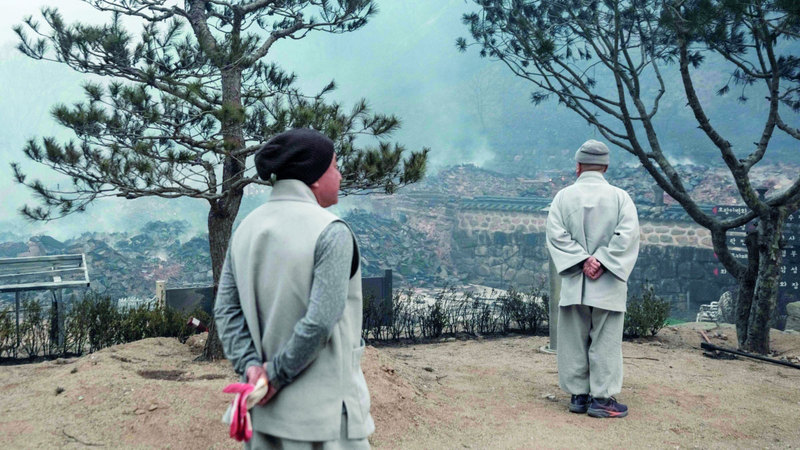 سكان يتفقدون منطقتهم بعد أن دمرها الحريق. أ.ف.ب