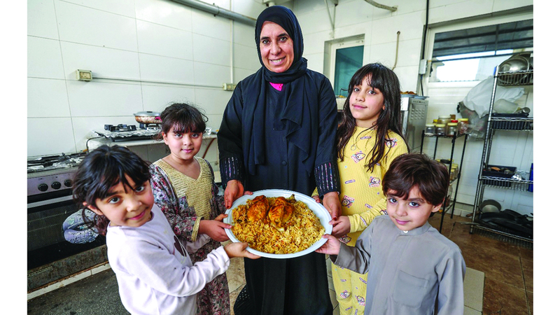 أحفاد «أم عبدالله».. يشاركون في تغليف الطعام. الإمارات اليوم
