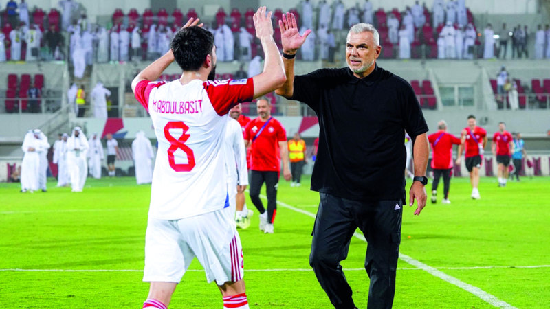كوزمين يهنئ لاعبه محمد عبدالباسط بعد الفوز على التعاون. الإمارات اليوم