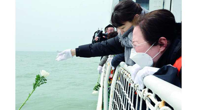 كوريون يلقون الزهور في البحر تكريماً للضحايا. إي.بي.إيه