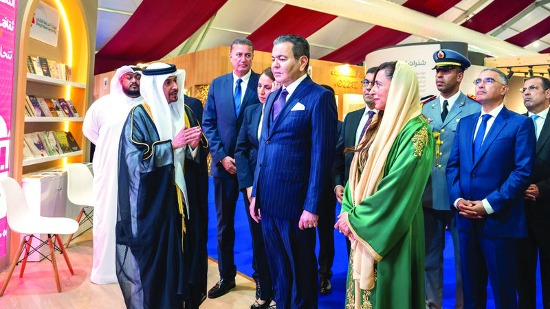 مولاي رشيد وبدور القاسمي يستمعان إلى شرح من رئيس هيئة الشارقة للكتاب. من المصدر