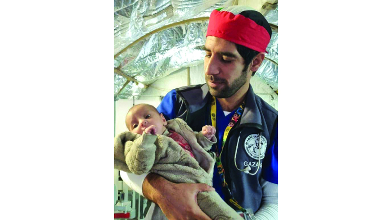 نافع الياسي مع طفلين من المصابين داخل المستشفى الإماراتي الميداني. من المصدر