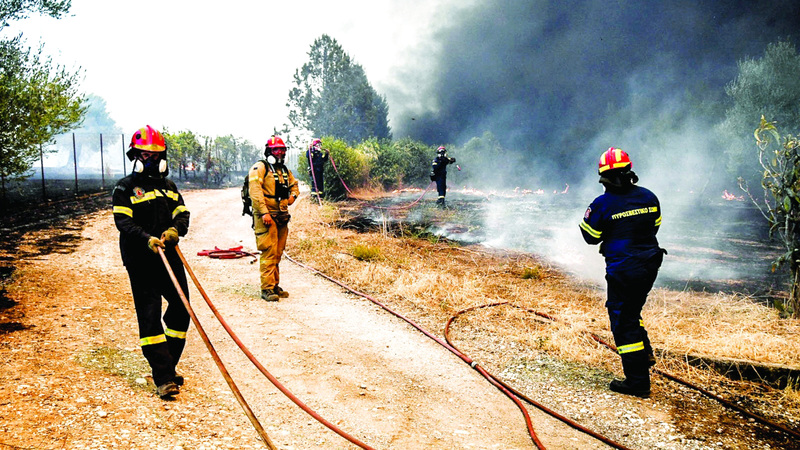 أفراد الدفاع المدني يحاولون السيطرة على حريق. رويترز