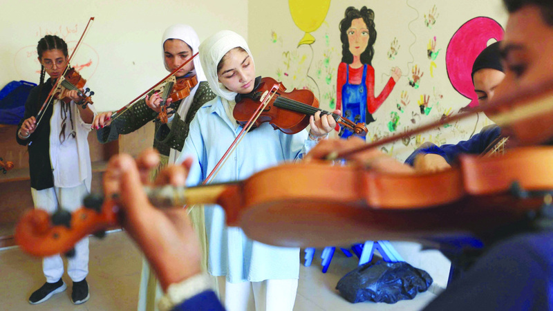 أكثر من 10 طلاب تجمعوا للتدرب على آلات موسيقية محفوظة بعناية لحمايتها من أضرار الحرب. رويترز