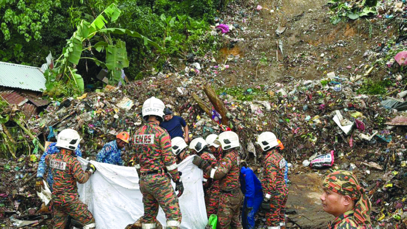 رجال إنقاذ يبحثون عن ناجين في موقع انهيار أرضي بإحدى قرى كولومبونغ. إي.بي.إيه
