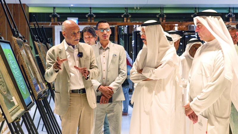 تاج السر حسن يشرح لضيوف المعرض خصوصية لوحاته. تصوير: شيماء محمد