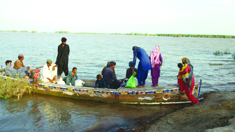 سكان يستخدمون قوارب صغيرة لإنقاذ المحاصرين وسط مياه الفيضانات. إي.بي.إيه