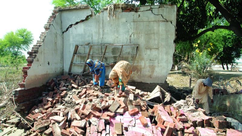 متضررون يتفقدون ما تبقى من منازلهم التي دمرتها الفيضانات. رويترز