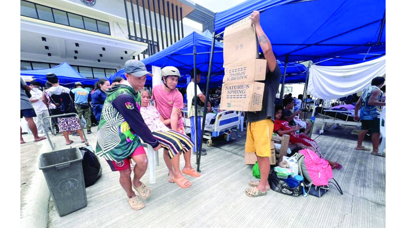 سكان محليون يحملون امرأة مُسنة مصابة في أعقاب الزلزال بمدينة بوغو. إي.بي.إيه