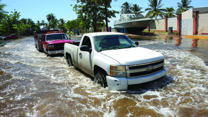 سيارات تشق طريقها في مياه الفيضانات. رويترز