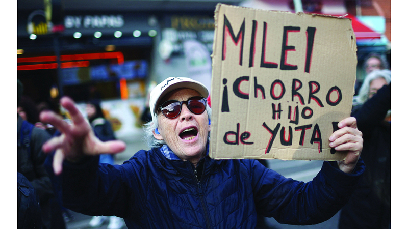 متظاهر يحمل لافتة تنتقد سياسات الرئيس الأرجنتيني. رويترز