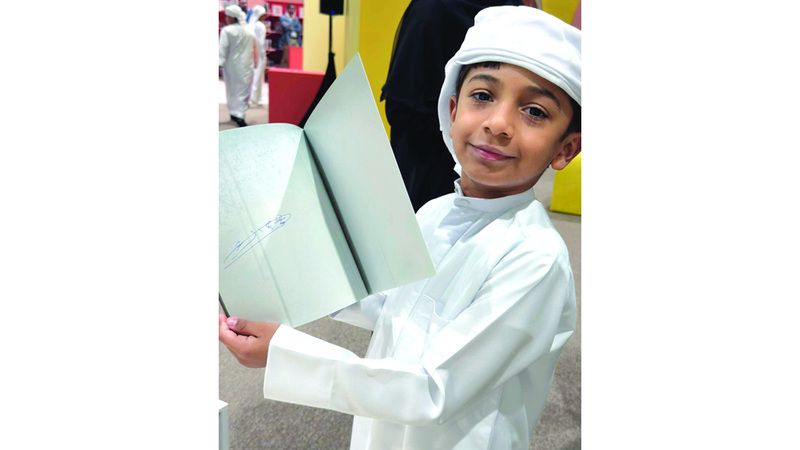 محمد الكعبي سعيداً بتوقيع ولي عهد الفجيرة على كتابه. من المصدر