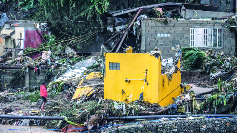 رجل يتفقد منزله بعد الإعصار. إي.بي.إيه