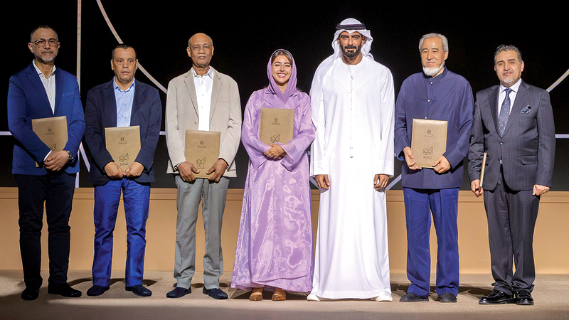 سالم القاسمي يتوسط فائزين في إحدى فئات &laquo;الجائزة&raquo;. من المصدر