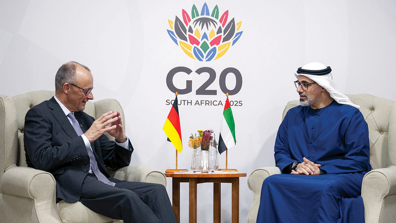 خالد بن محمد خلال لقائه المستشار الألماني على هامش القمة. وام