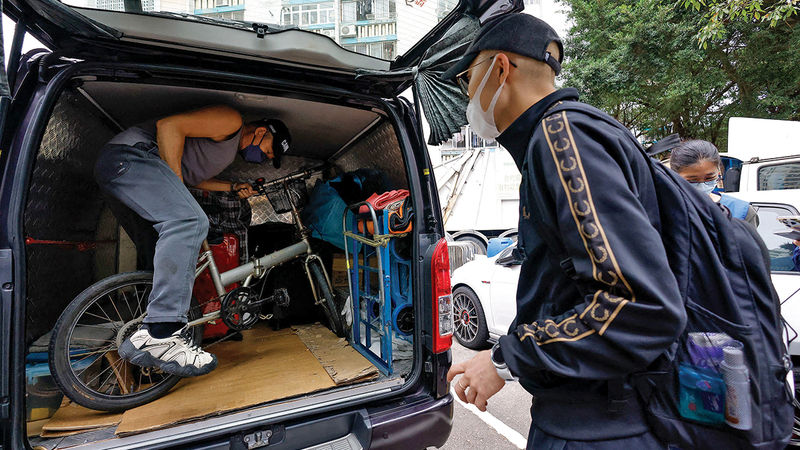 سائق يساعد أحد السكان على تحميل دراجة هوائية في السيارة. رويترز