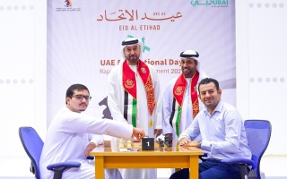 الصورة: لاعب ووالده يصعدان منصة التتويج في بطولة عيد الاتحاد الـ54 للشطرنج السريع