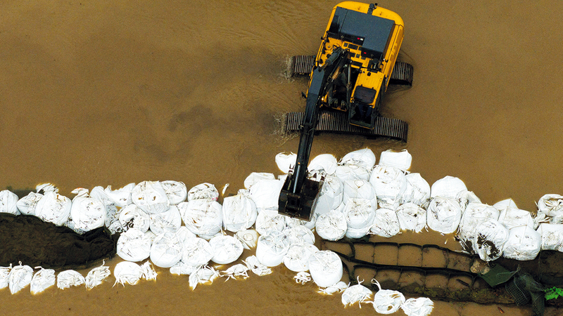 إجراء أعمال صيانة لأحد الحواجز المؤقتة للفيضانات. رويترز