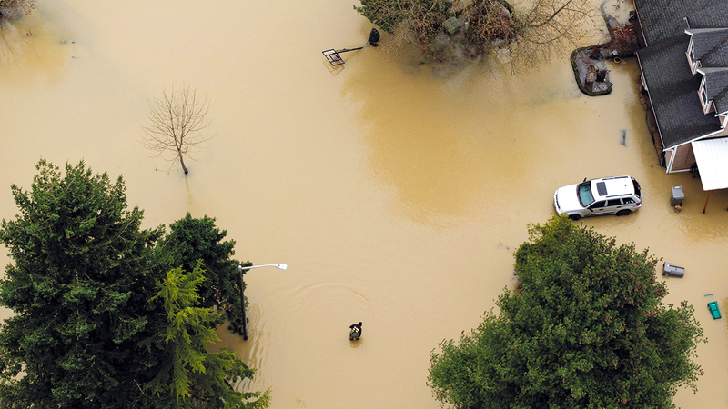 أحد السكان يحاول الوصول إلى سيارته وسط مياه الفيضانات. رويترز