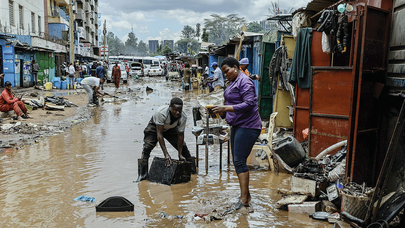 رجل وامرأته ينظفان مخلفات الفيضانات. إي.بي.إيه