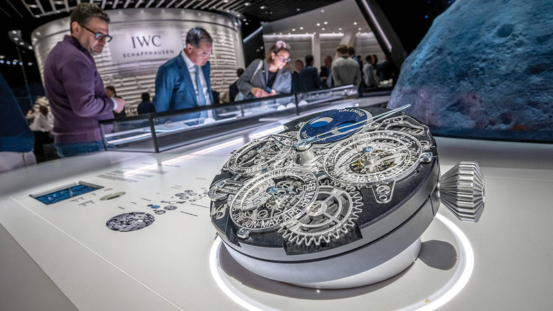 زوار يشاهدون نموذجاً يُظهر آلية عمل إحدى الساعات الفاخرة. أ.ف.ب