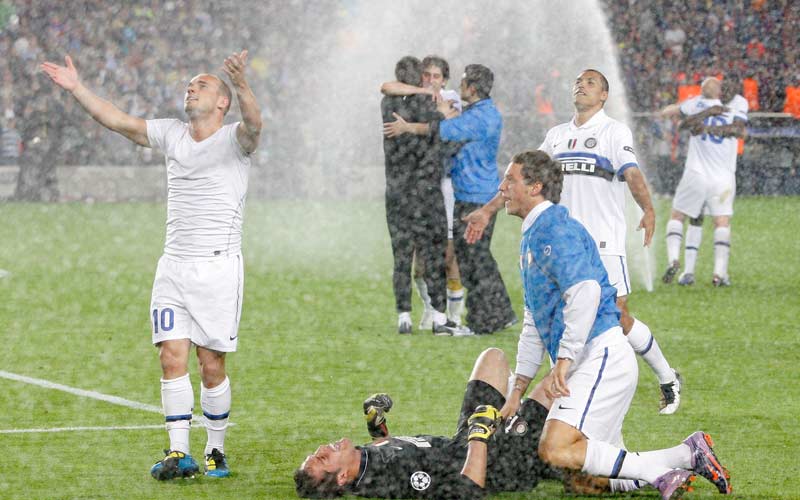 لاعبو الإنتر يحتفلون بالتأهل في الوقت الذي جرى فتح رشاشات المياه في الملعب لحملهم على تركه ووقف الاحتفال. أ.ب