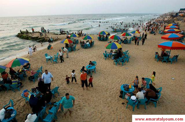 عوائل تهرب من حر الصيف بالاستمتاع على شاطئ البحر في غزة. رويترز