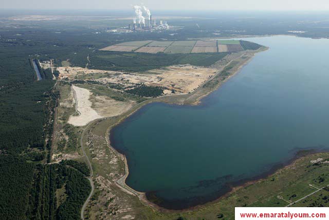 البخار يرتفع من أبراج التبريد في محطة الطاقة "بوكس بيرغ" الالمانية التى تعمل بالفحم وتتوسط عدد من البحيرات والغابات -غيتى