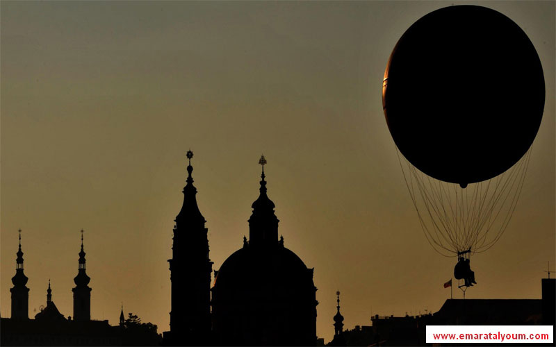 منطاد يحلق فوق سماء مدينة براغ التشيكية وقت الغروب. إي بي أيه