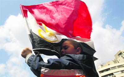 طفل يحتضن علم مصر في ميدان التحرير أثناء الاحتجاجات الشعبية. 	  	رويترز