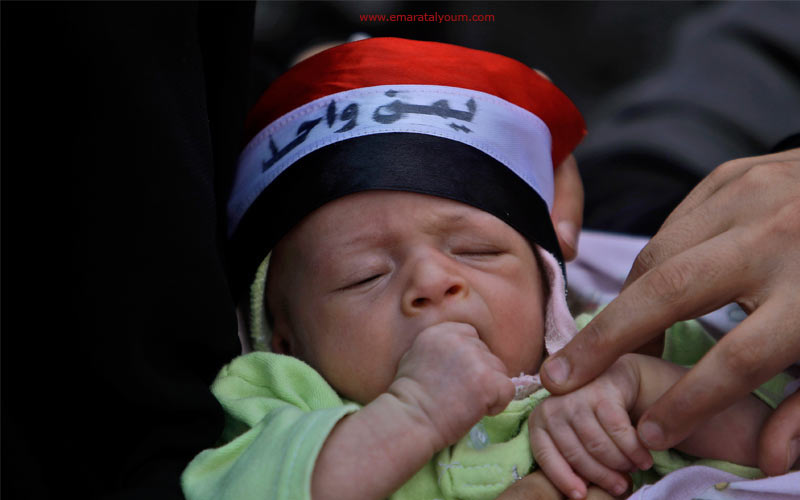 رضيع يحلم بـ"يمن جديد" خلال مشاركة والدته في إحدى المسيرات المناهضة لنظام الرئيس اليمني-أ.ب