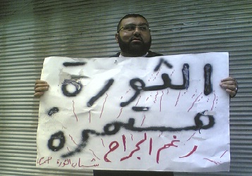 متظاهر سوري من حمص يرفع شعار مناهض للنظام.  رويترز