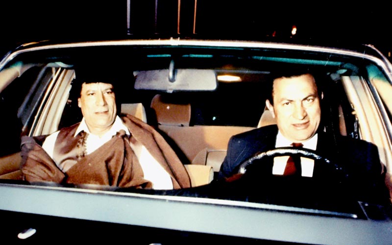 1990.. الرئيس المصري المخلوع، حسني مبارك، يقود سيارته وبجانبه القذافي في ميدان التحرير خلال انعقاد إحدى اجتماعات القمم العربية-أ.ب