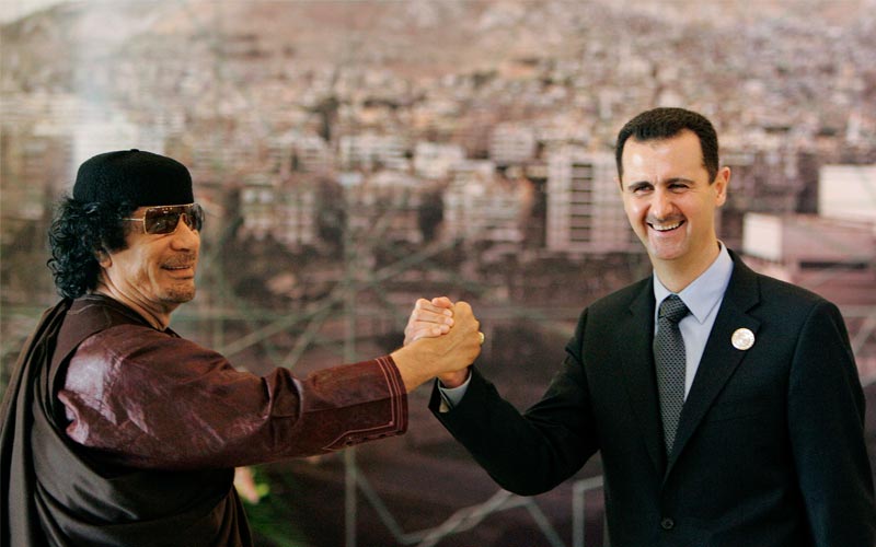 2008.. القذافي يمسك بيد الرئيس السوري، بشار الأسد، خلال القمة العربية التي استضافتها العاصمة السورية، دمشق-أ.ب