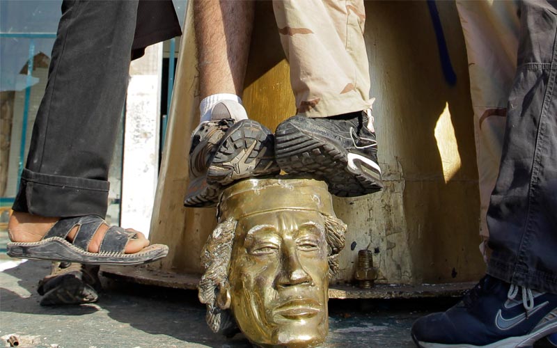 23 أغسطس 2011.. الثوار يركلون رأس تمثال للقذافي بعد أن اقتحموا منزله واجبروه على الفرار إلى جهة مجهولة-أ.ب