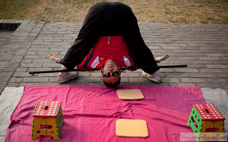 الرياضة الصباحية على الطريقة الصينية يؤديها هذا المواطن الصيني في المتنزه. إي بي أيه