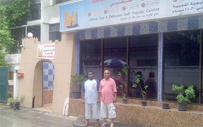 سعيد آل علي وابنه إبراهيم أمام مدخل المطعم.   الإمارات اليوم