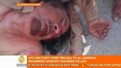 لقطات بثتها قناة الجزيرة تظهر جثة الزعيم المخلوع وقد جرد من قميصه.