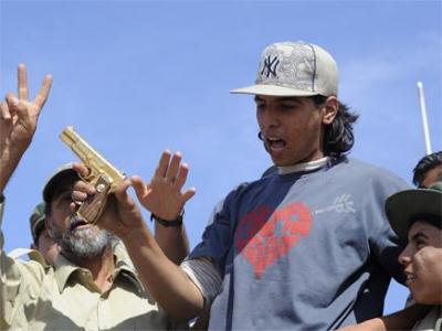 الشيباني حاملاً مسدساً ذهبياً قيل أنه للقذافي - العربية