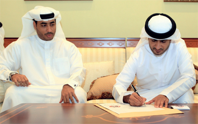 سيف الكتبي يوقع على وثيقة «أتعهد» وإلى جواره سامي الريامي.   تصوير: باتريك كاستيلو