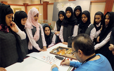 عدد من الطالبات حول الخطاط خضير البورسعيدي.  من المصدر