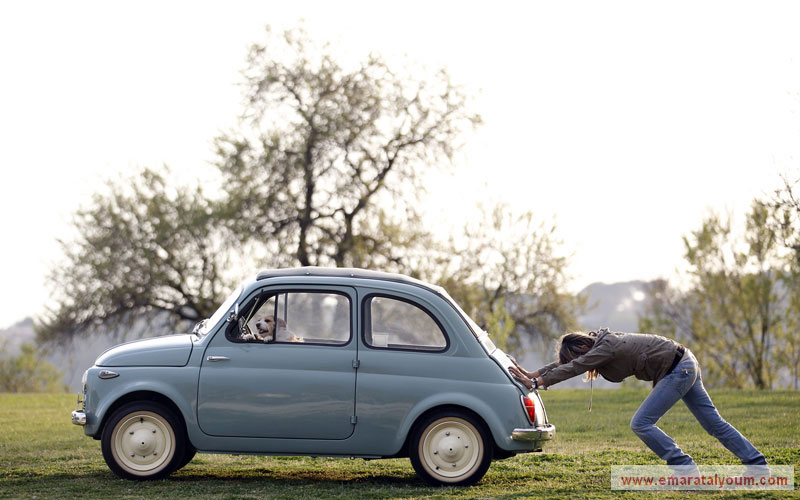 وآخر يقضي وقتاً ممتعاً في سيارة صاحبته التي أضناها تعب دفع السيارة العاطلة. رويترز