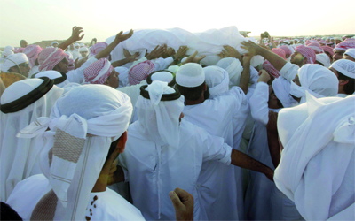 المشيعون يحملون جثمان سيف الكعبي إلى مثواه الأخير.	 تصوير: إريك أرازاس