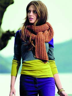 طلة تتألف من سروال مؤف وبلوفر ذي تقليمات ملونة وشال بني.