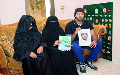 والدة ناصر وشقيقه يحملان صورته